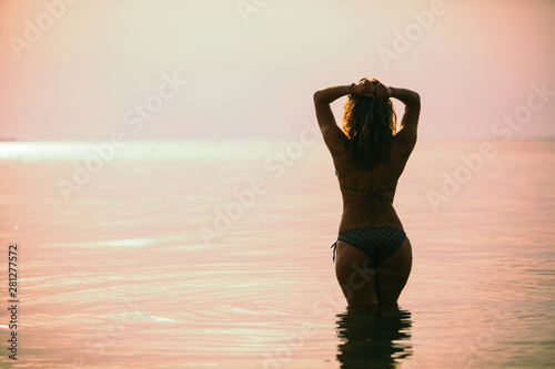 woman in swimming suit in front of sea no face