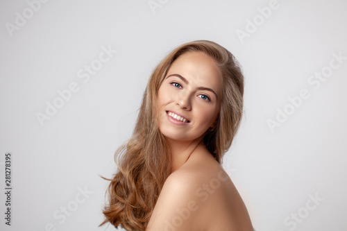 Beautiful smiling woman portrait with long blonde hair and perfect fresh skin. Happy blonde woman looking at the camera.