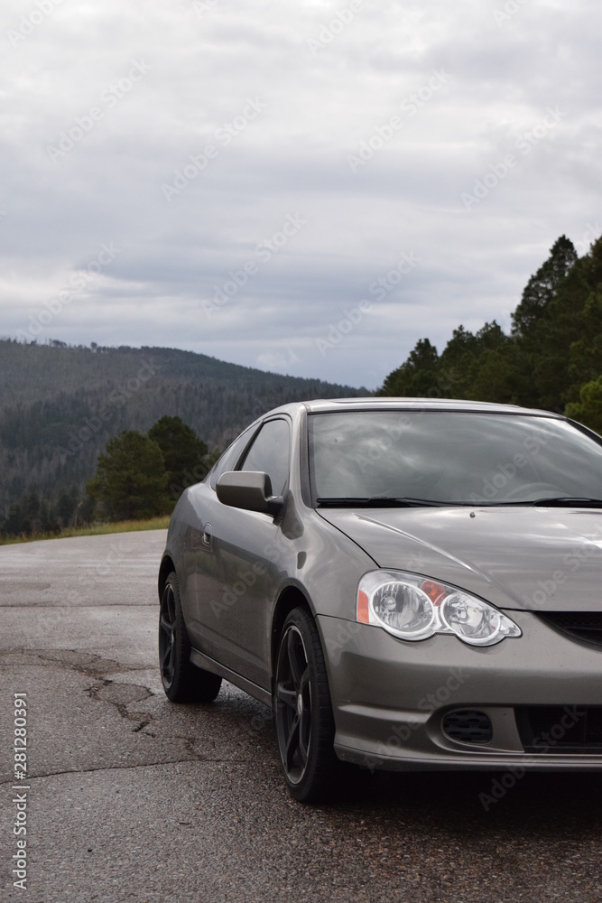 Grey sports car on the road with mountain background