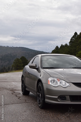 Grey sports car on the road with mountain background © Brian