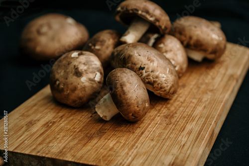Champignons mushrooms on wooden board on black background