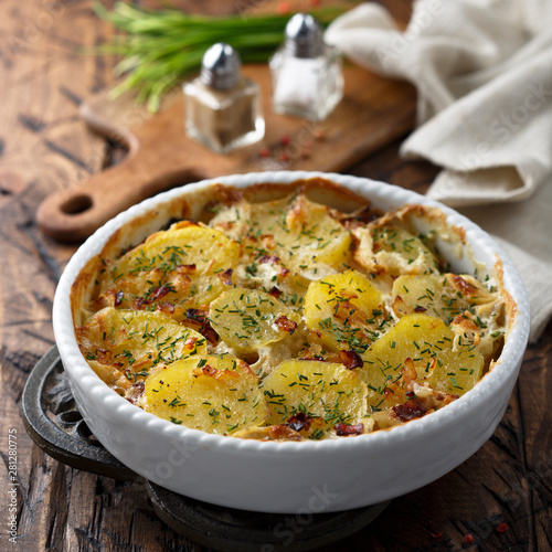 Homemade potato gratin with bacon and herbs