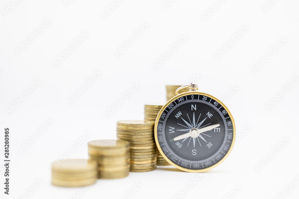 Succession, Finance, Business, Money, Security, Planning and Saving Concept. Close up of compass with stack of gold coins on white background and copy space.