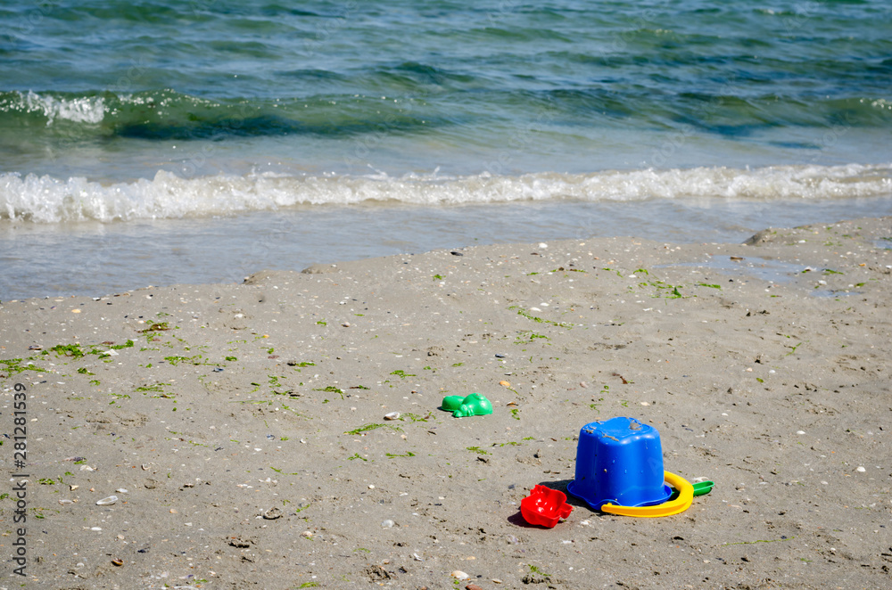 Close-up view of different kids toys on sand beach . Close-up view of different kids toys on sand beach .