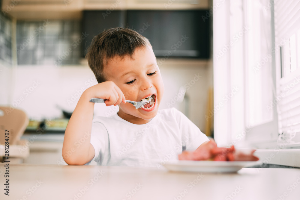 child in the kitchen eating sausage and mashed potatoes child in the kitchen eating sausage and mashed potatoes