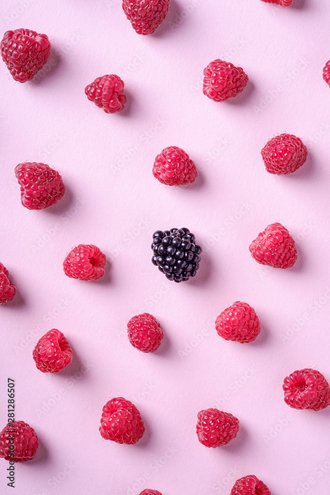 Raspberry sweet organic juicy berries with single blackberry, pattern, texture, on pink paper background, flat lay Raspberry sweet organic juicy berries with single blackberry, pattern, texture, on pink paper background, flat lay