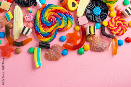 mixed colorful sweets and candies over pink like festive background with copy space