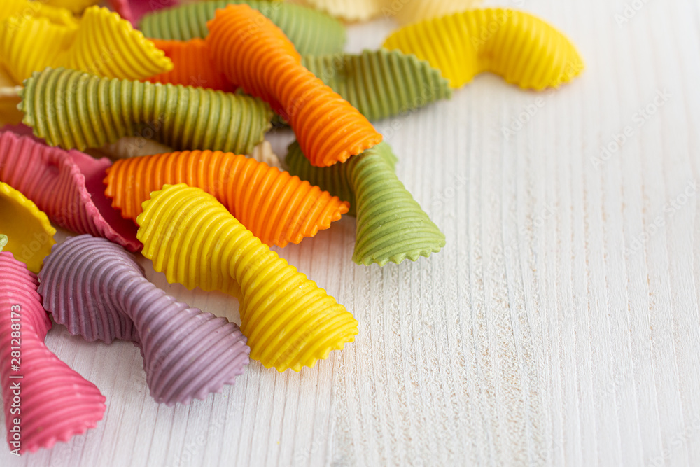 Top view of colored pasta on white wooden background with copy space Top view of colored pasta on white wooden background with copy space