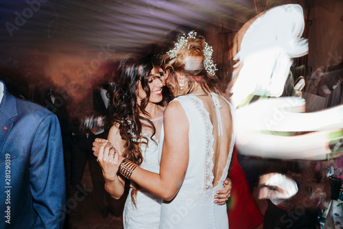 Portrait of a proud couple dancing each other with white wedding dresses photo