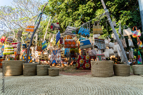 Traditional african market selling colorful  bags hanged on trees, Maputo, Mozambique © eunikas