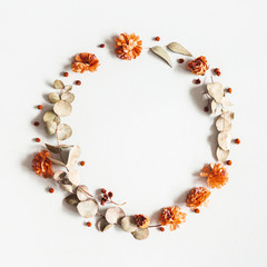 Autumn composition. Wreath made of dried flowers, eucalyptus leaves, berries on gray background. Autumn, fall, thanksgiving day concept. Flat lay, top view, copy space, square