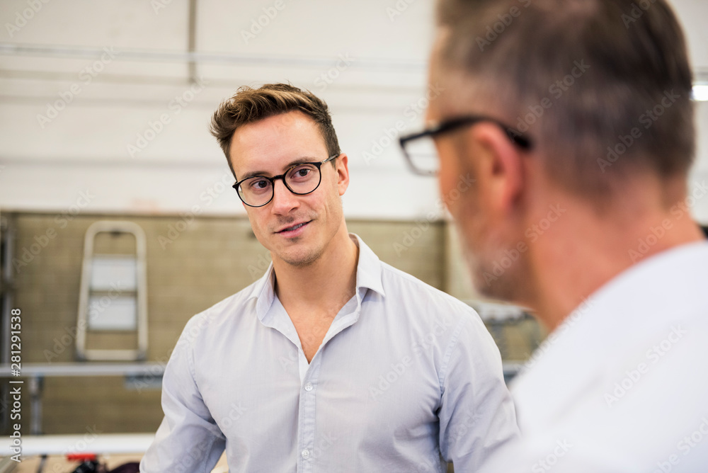 Two businessmen discussing in factory