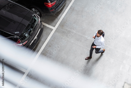 Young businessman with backpack on the go at parking garage photo