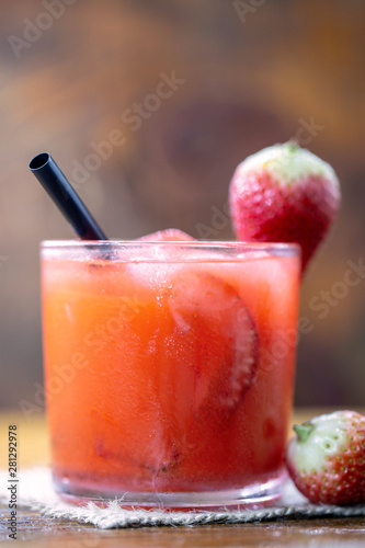 Fresh strawberry drink on wood background, Brazilian Strawberry Caipirinha is on the bar. Space for text. Photo for the menu.