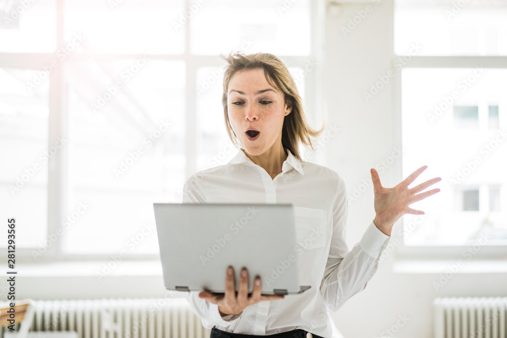 Amazed woman holding laptop Amazed woman holding laptop