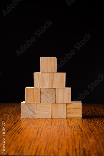 Wooden blocks stacked against black background