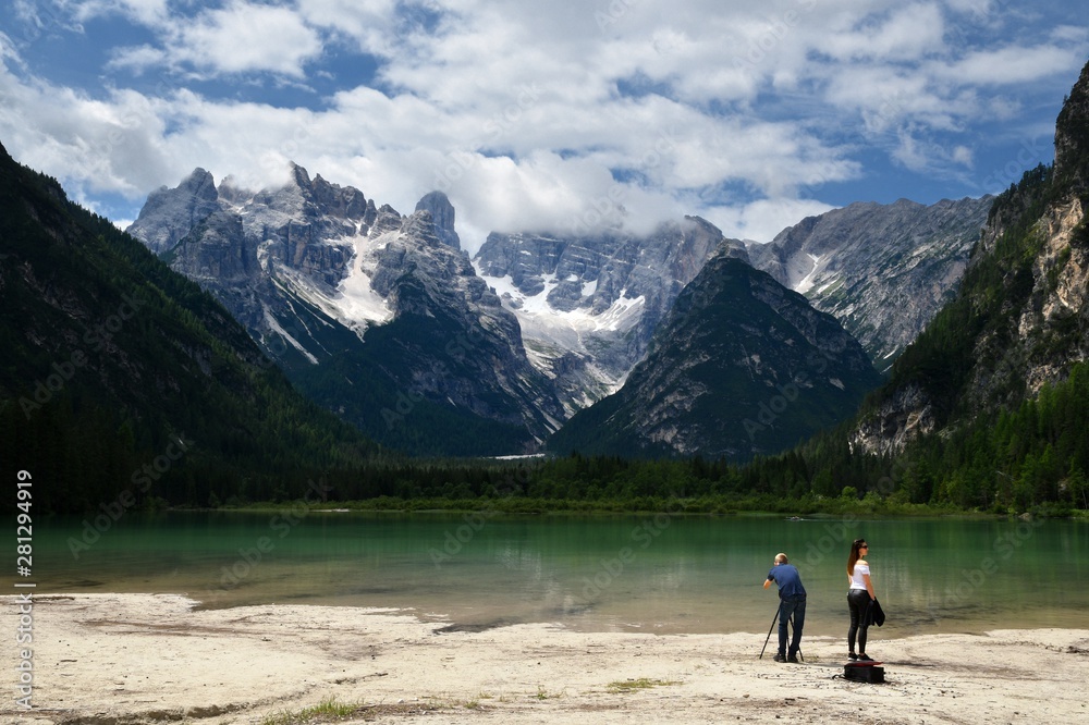 Dobbiaco (Bolzano) July 2019: tourists at the beautiful Lake Landro near Dobbiaco with the Dolomite Dolomite massif in the background. South Tyrol, Italy. Dobbiaco (Bolzano) July 2019: tourists at the beautiful Lake Landro near Dobbiaco with the Dolomite Dolomite massif in the background. South Tyrol, Italy.