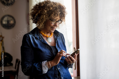 Woman using phablet by the window photo