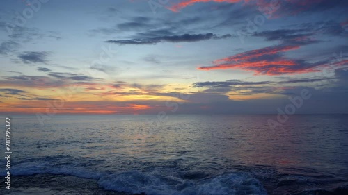 Sunset ocean beach with rock and blue sky