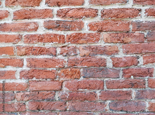 Fragment of an old historic red brick wall as a background or texture