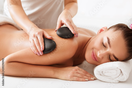 Relaxed woman getting stones arm massage in spa