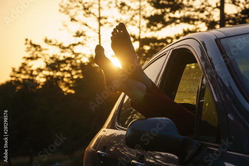 Two feet of the ground, young woman in the car barefooted