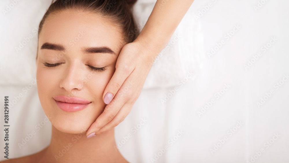 Woman getting facial spa treatment, enjoying face massage Woman getting facial spa treatment, enjoying face massage