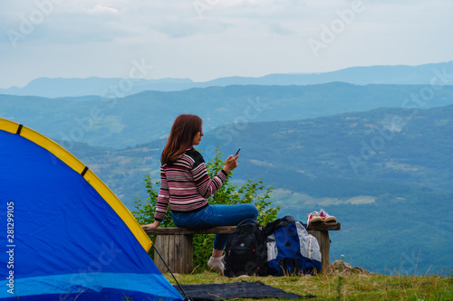 Young woman in jeans camping at amazing sightseeng spot photo