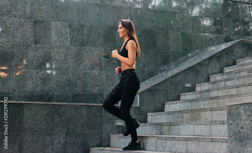 Fit woman in sportswear runs on the marble stairs outdoor. Morning running. Healthy lifestyle concept © splitov27