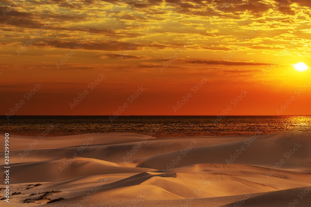 Beautiful sand dunes, ocean and red sunset in the Namib  desert