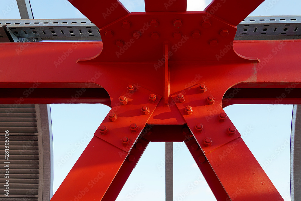 Red iron beams bolted. Asymmetrical connection of several iron beams