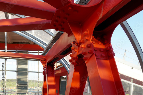 Red iron beams bolted on. Angular connection of several iron beams in one place close up.