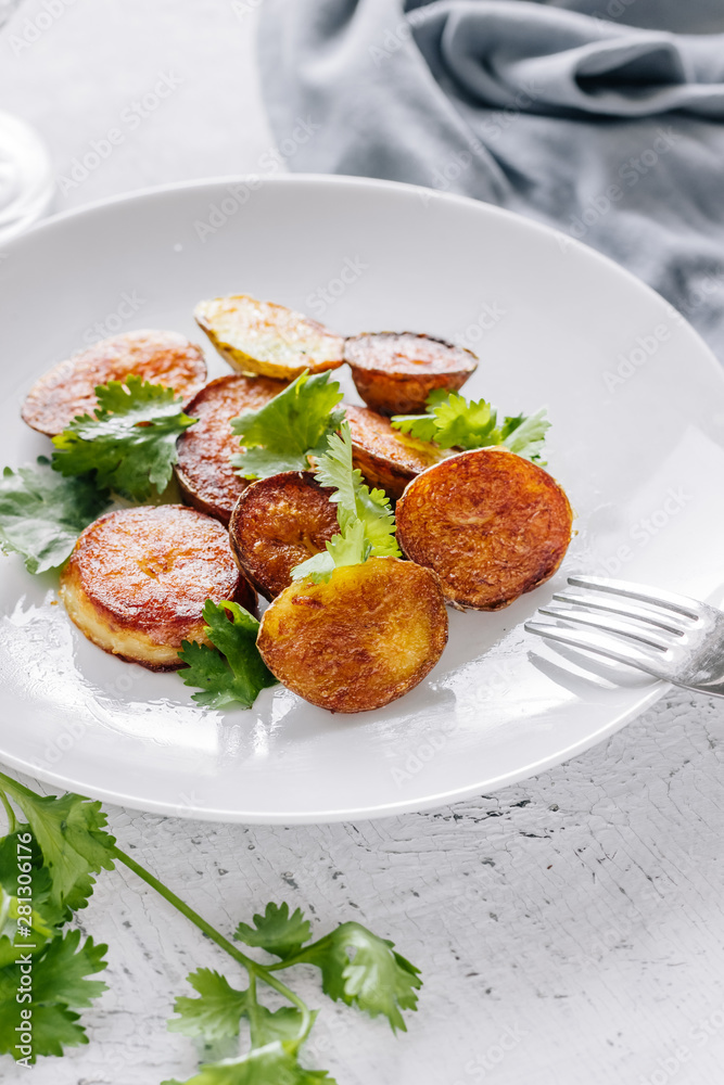 Baked potatoes with cilantro in a plate Baked potatoes with cilantro in a plate
