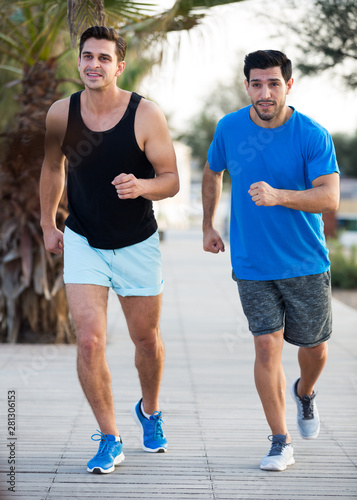 Smiling sportsmen are joggning in time warm-up © JackF