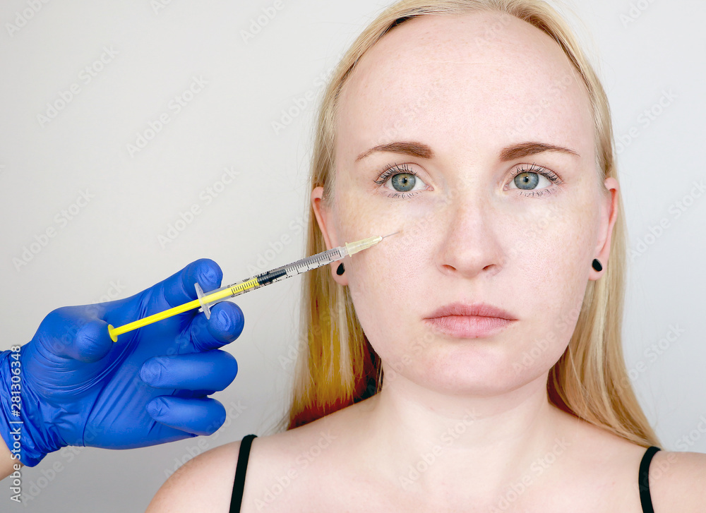 A cosmetologist carries out a procedure - an injection into the face of a young woman. Beauty injections, mesotherapy, hyaluronic acid injections, biorevitalization, cheek correction, fillers A cosmetologist carries out a procedure - an injection into the face of a young woman. Beauty injections, mesotherapy, hyaluronic acid injections, biorevitalization, cheek correction, fillers