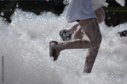 Denver, Colorado: Bubble Run in Lowry Sports Park is a special event fund raiser. Running legs close up. photo