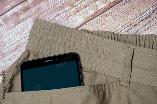 Quadro em tela black smartphone sticking out of pocket light pants