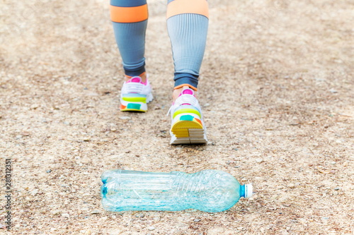 Woman left behind empty plastic water bottles on park path