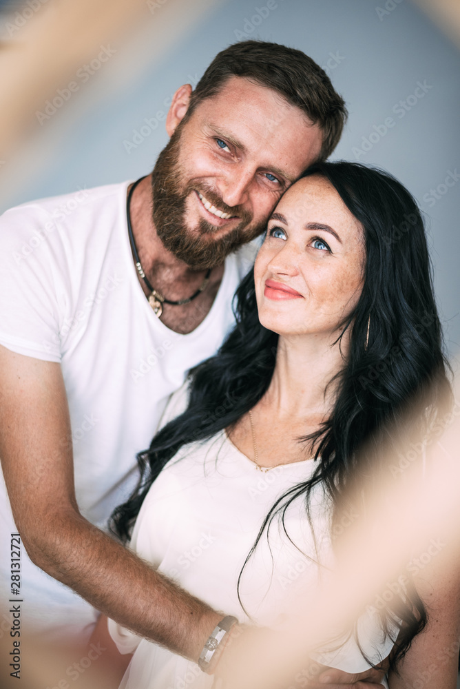 Loving couple woman and man with beard soft light from window