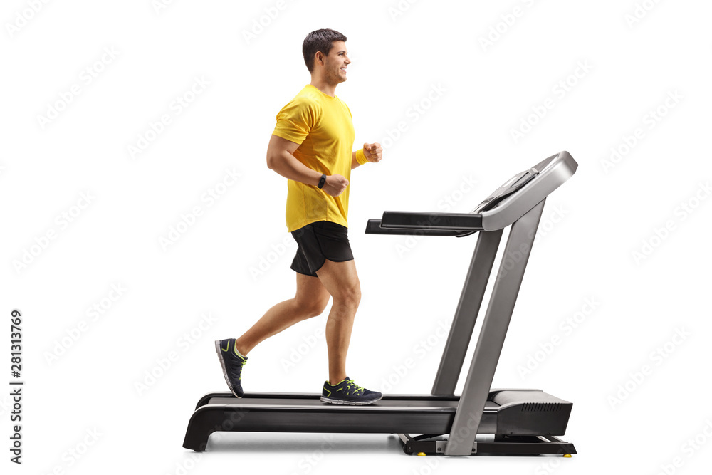 Fototapeta premium Young man running on a professional treadmill