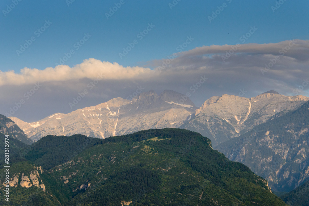 Landscape of the Olympus mountain range. View of a high rocky peaks in the distance and hillsides are covered with forest. It is highest mountains in Greece. National Park. World Biosphere Reserve.