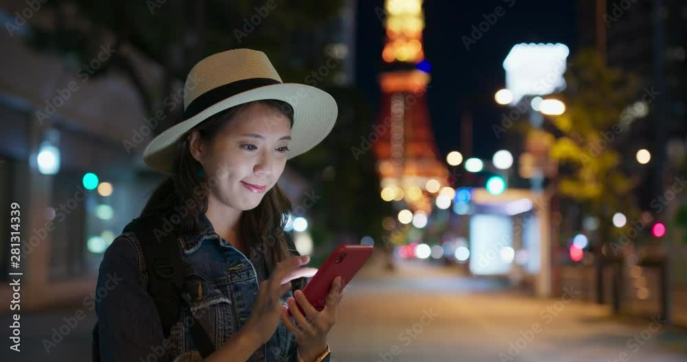 Woman use of mobile phone in Tokyo city at night
