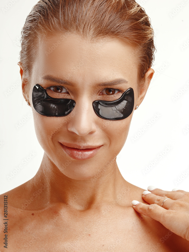 Young attractive girl with black patches on her face. Smoothing wrinkles. Concept skin care face. Young attractive girl with black patches on her face. Smoothing wrinkles. Concept skin care face.