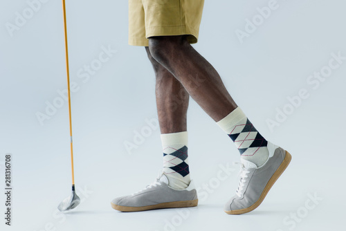cropped view of african american sportsman holding golf club on grey background