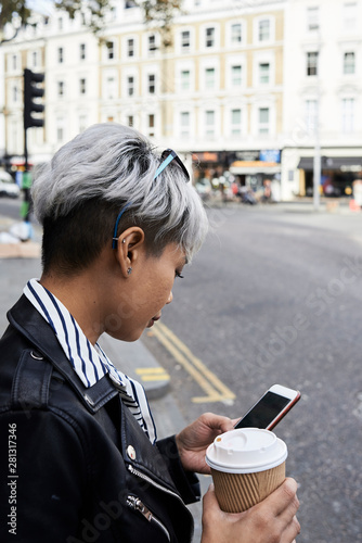 Asian lady using smartphone street.