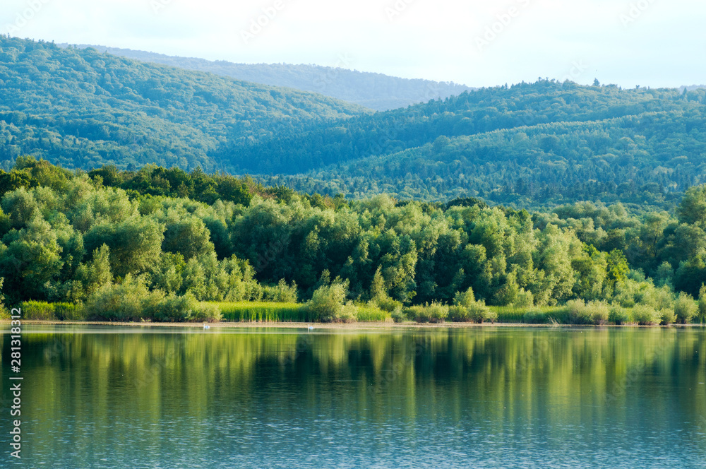 beautiful summer lake against the background of high mountains and blue sky