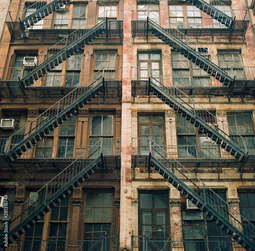 An old brick building with merging fire escape stairs