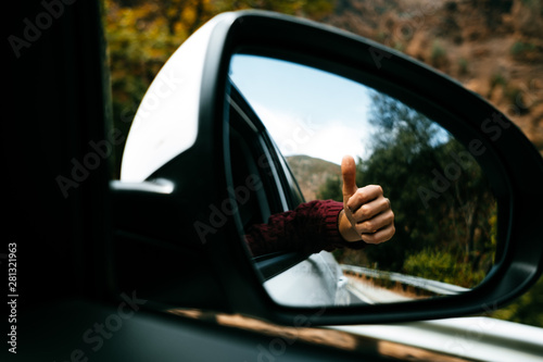 hand with tattoo seen from the rear-view mirror photo