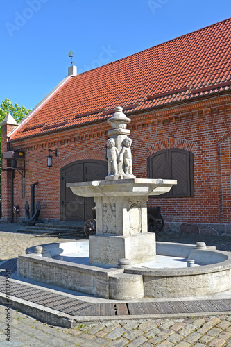 KALININGRAD, RUSSIA. The park Puttenbrunen fountain (Putti) against the background of the brick building of a warehouse