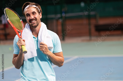 Tired tennis player with towel after training on tennis court